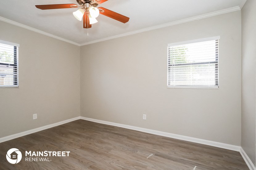the interior of an empty room with a ceiling fan