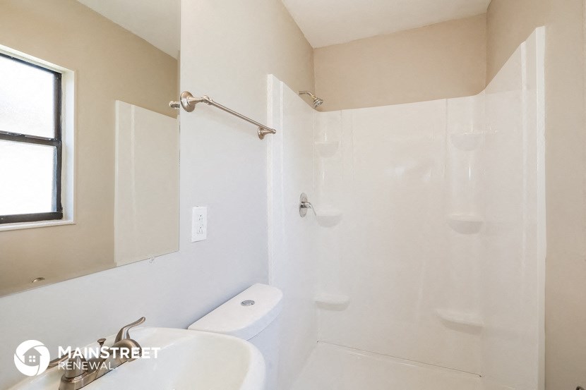a white bathroom with a shower and a sink and a toilet