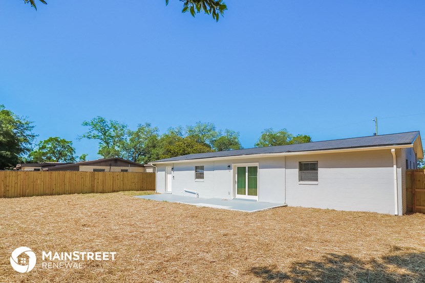 a small white house with a yard and a fence
