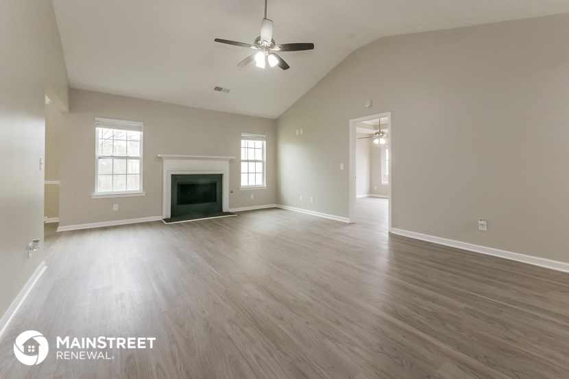the living room of an empty house with a ceiling fan