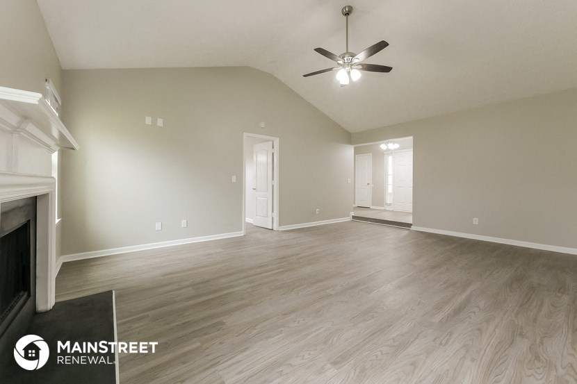 a living room with a fireplace and a ceiling fan
