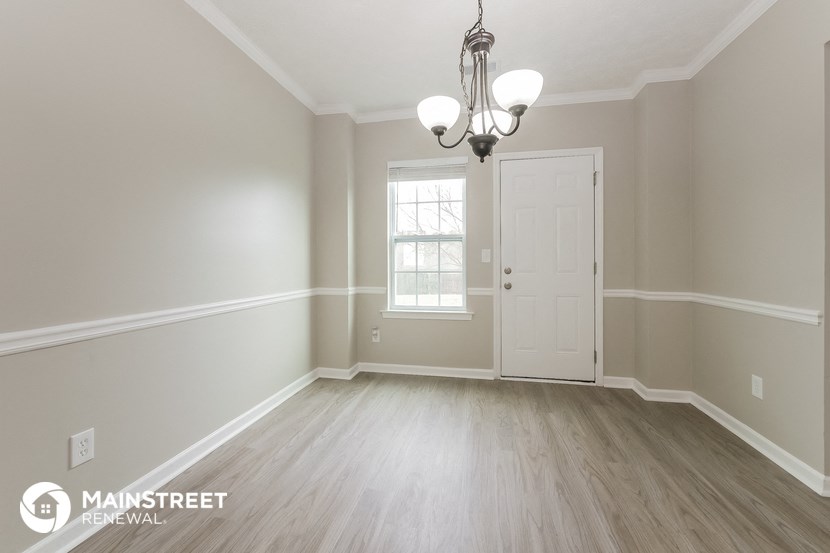 the dining room after remodeling with wood flooring and a chandelier