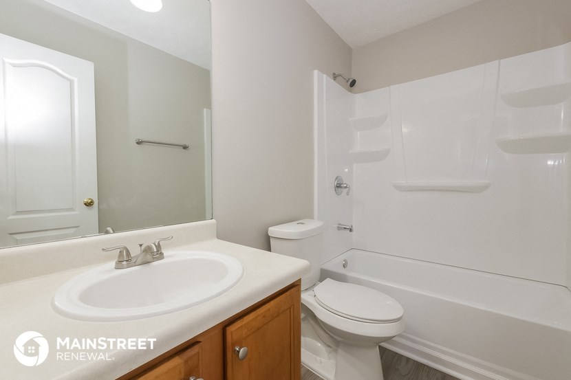 a bathroom with a sink toilet and tub and a mirror