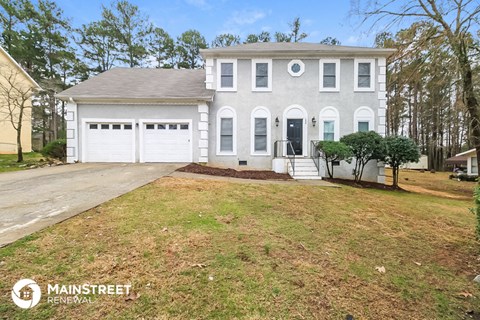 a white house with a driveway and a garage door