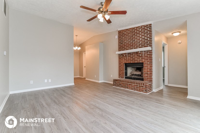 the living room of an empty house with a fireplace