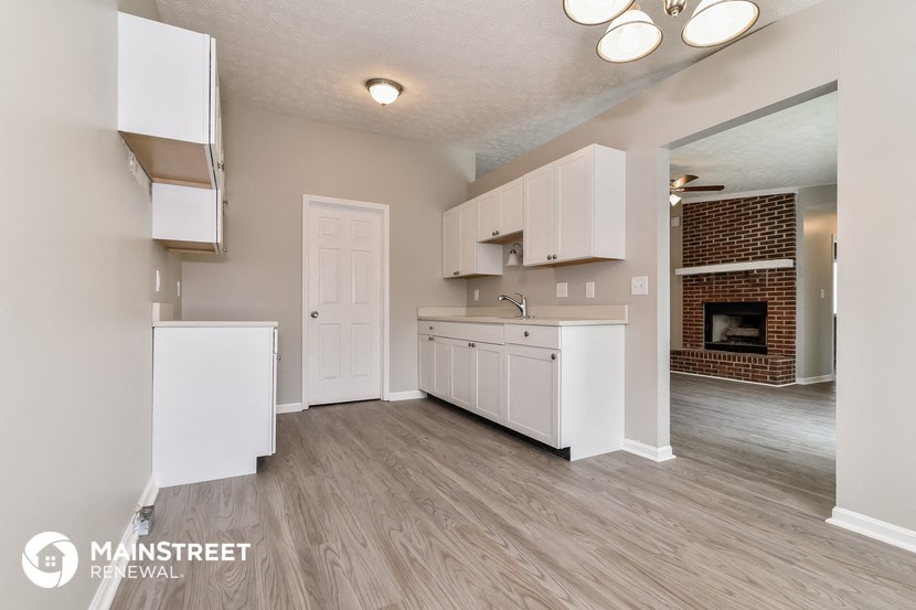 an open kitchen with white cabinets and a fireplace