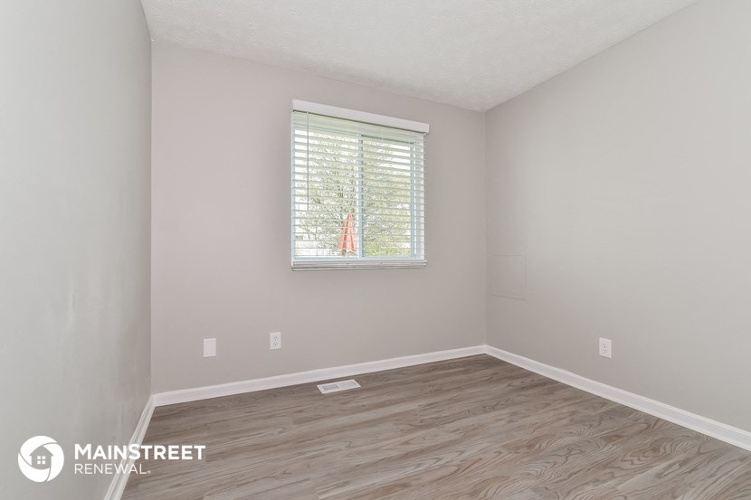 the interior of an empty room with wooden floors and a window