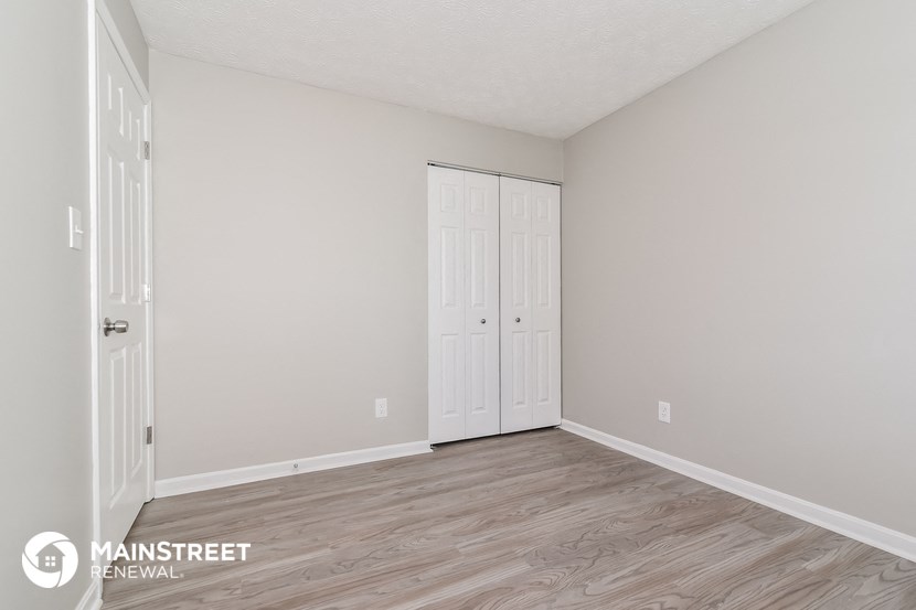the spacious living room with two closets and wood flooring