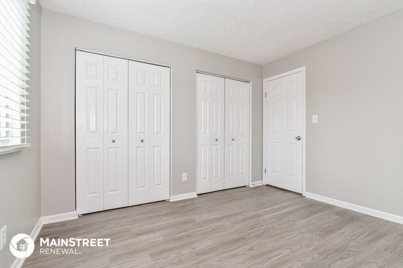 the spacious living room with three closets and a window
