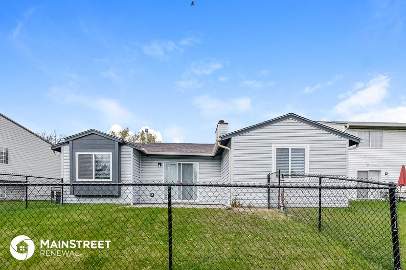 a home with a chain link fence in front of it
