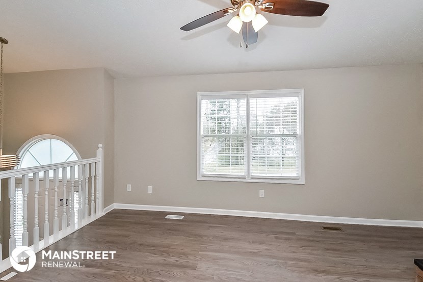the master bedroom has a staircase and a ceiling fan