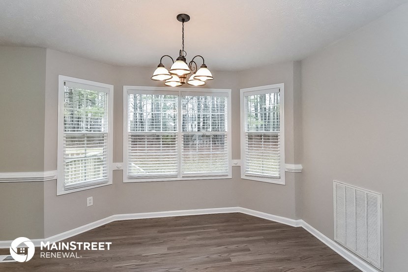 the dining room of a home with windows and a chandelier