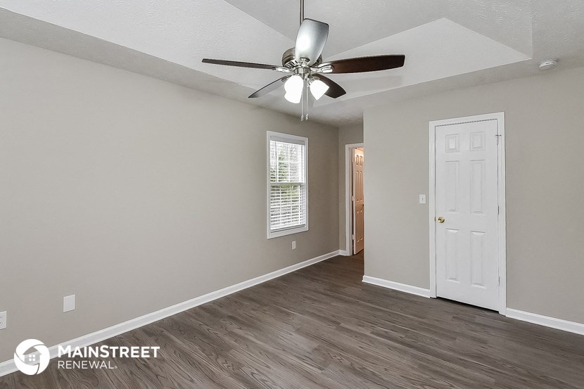 the living room of an apartment with a ceiling fan
