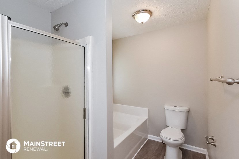 a bathroom with a toilet and a shower and a sink