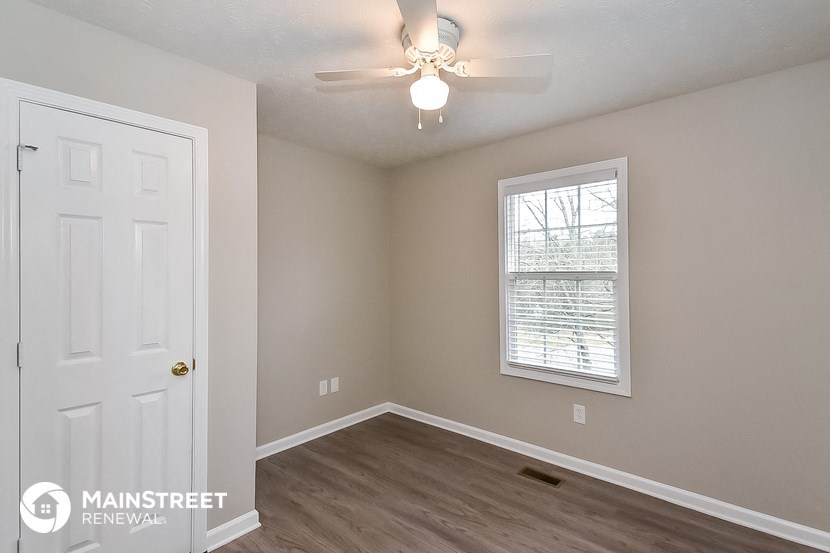 a bedroom with a white door and a ceiling fan