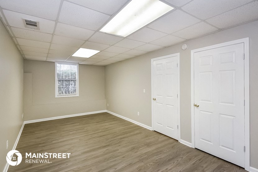the living room of an apartment with two white doors