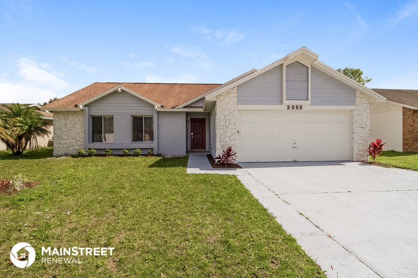 a white house with a driveway and a lawn
