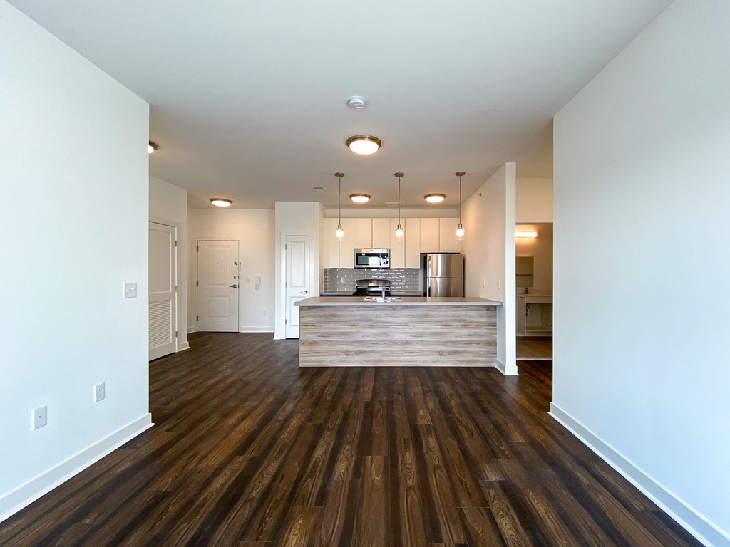 a view of a living room and kitchen with wood flooring