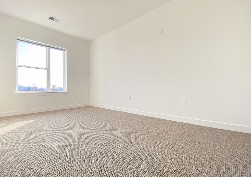 an empty room with carpet and a window