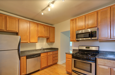 full kitchen with stainless steel appliances and wooden cabinets