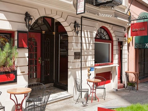the outside of a restaurant with tables and chairs outside