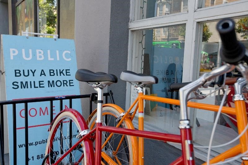 a bike parked on a fence next to a sign