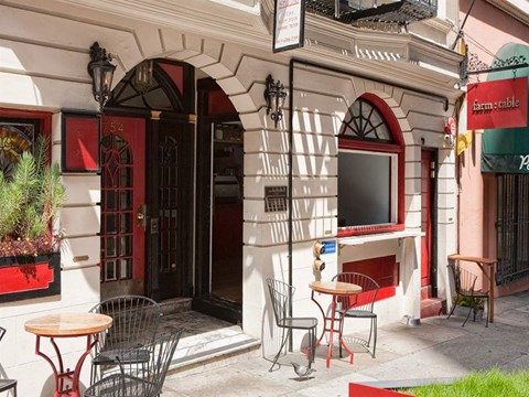 the outside of a restaurant with tables and chairs