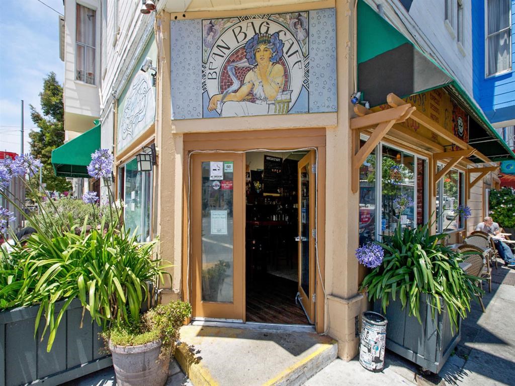 the front entrance of a restaurant with a stained glass window and potted plants