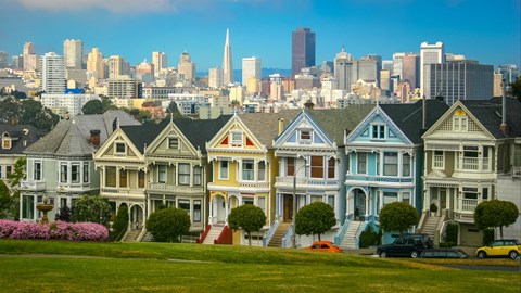 a row of colorful houses with a city in the background