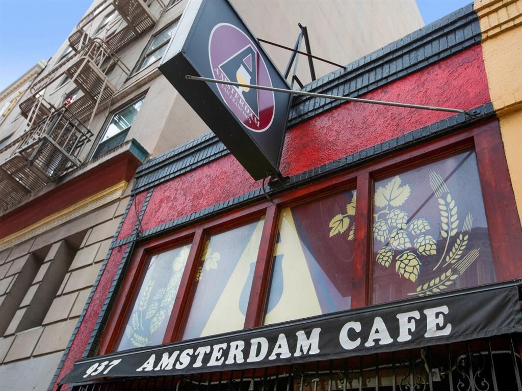 the front of a cafe with a sign on the side of a building