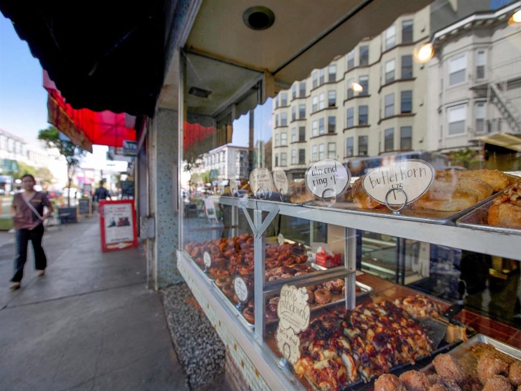 a display case filled with different types of pastries in a window