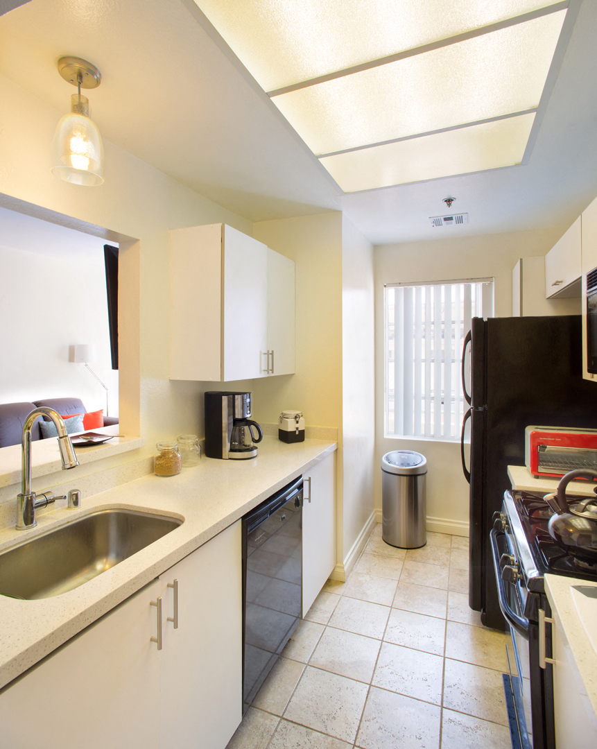 a kitchen with white cabinets and a sink and a window