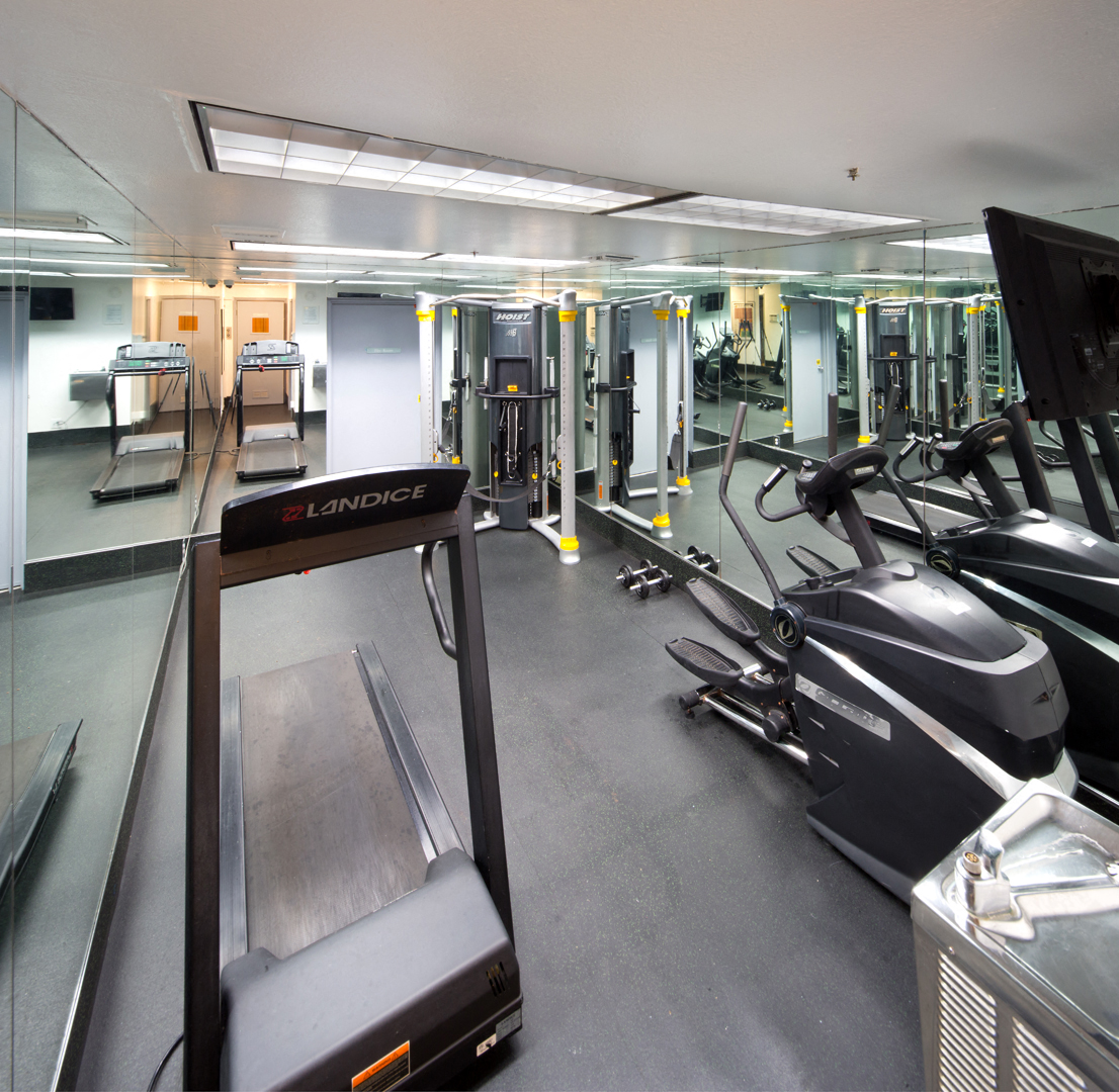 a gym with treadmills and other exercise equipment on the floor