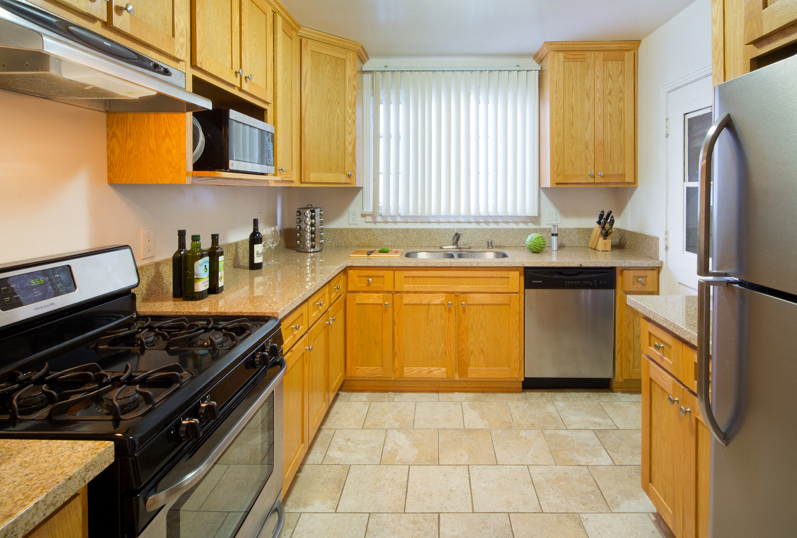 a kitchen with wooden cabinets and a stove and refrigerator
