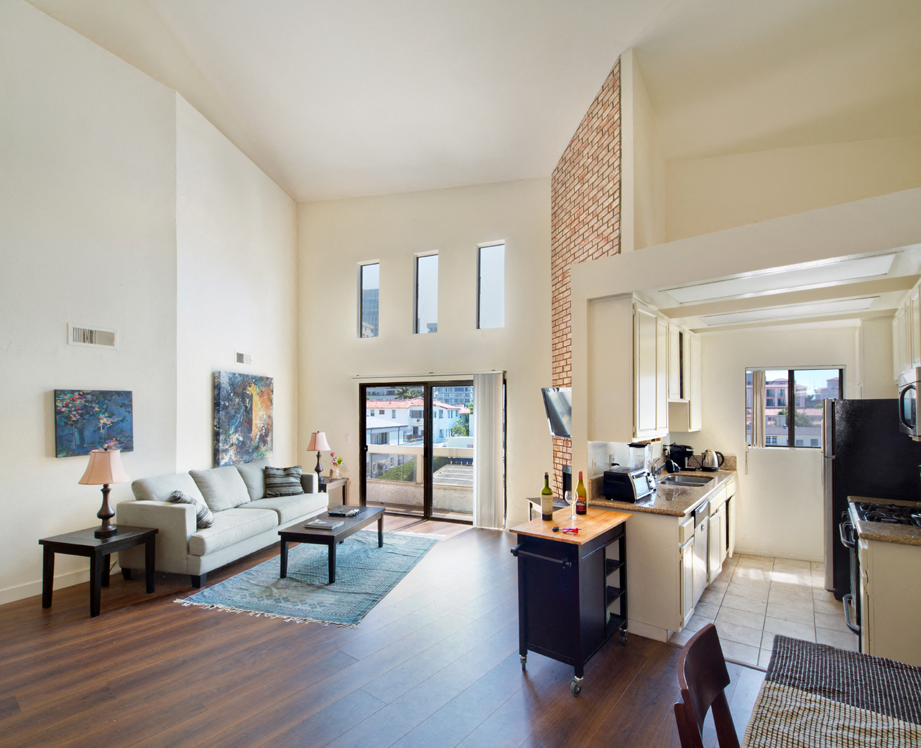 a living room with a couch and a table and a kitchen