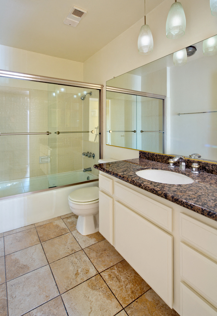 a bathroom with a toilet sink and shower and a mirror