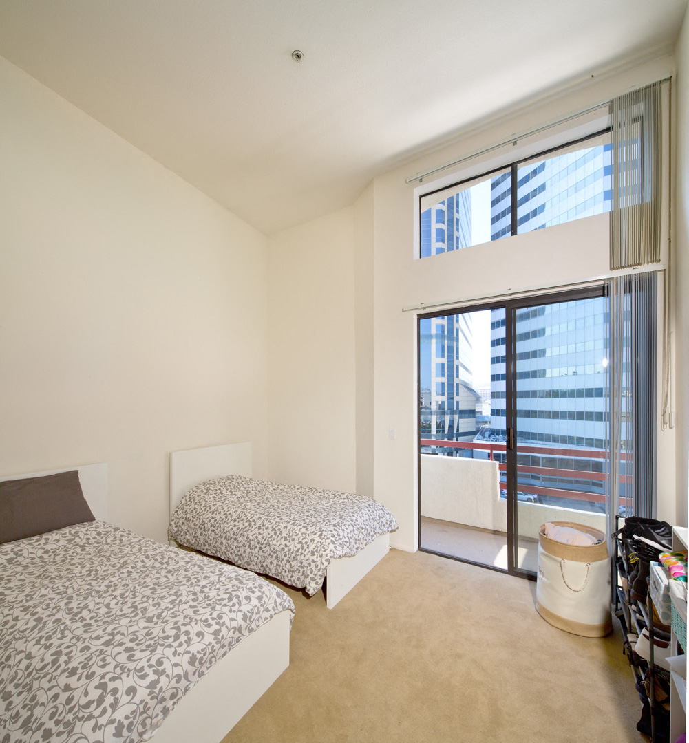 a bedroom with two beds and a door to a balcony