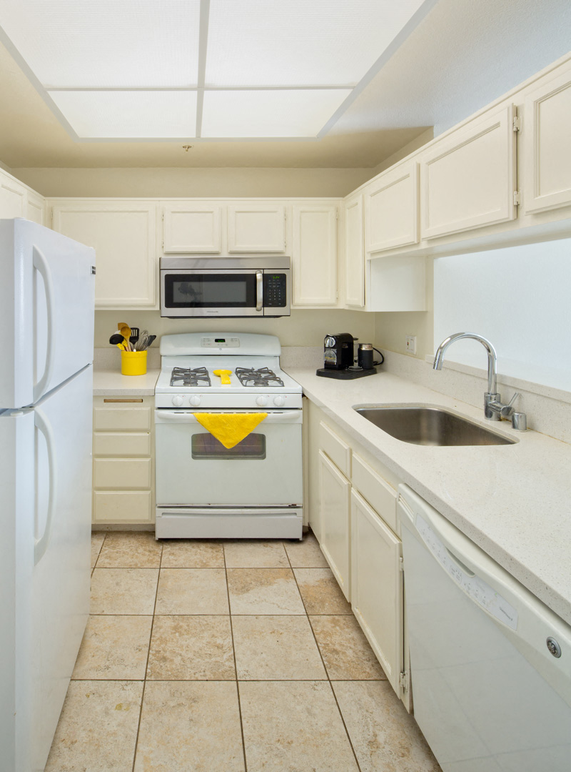 a kitchen with white cabinets and a stove and a sink