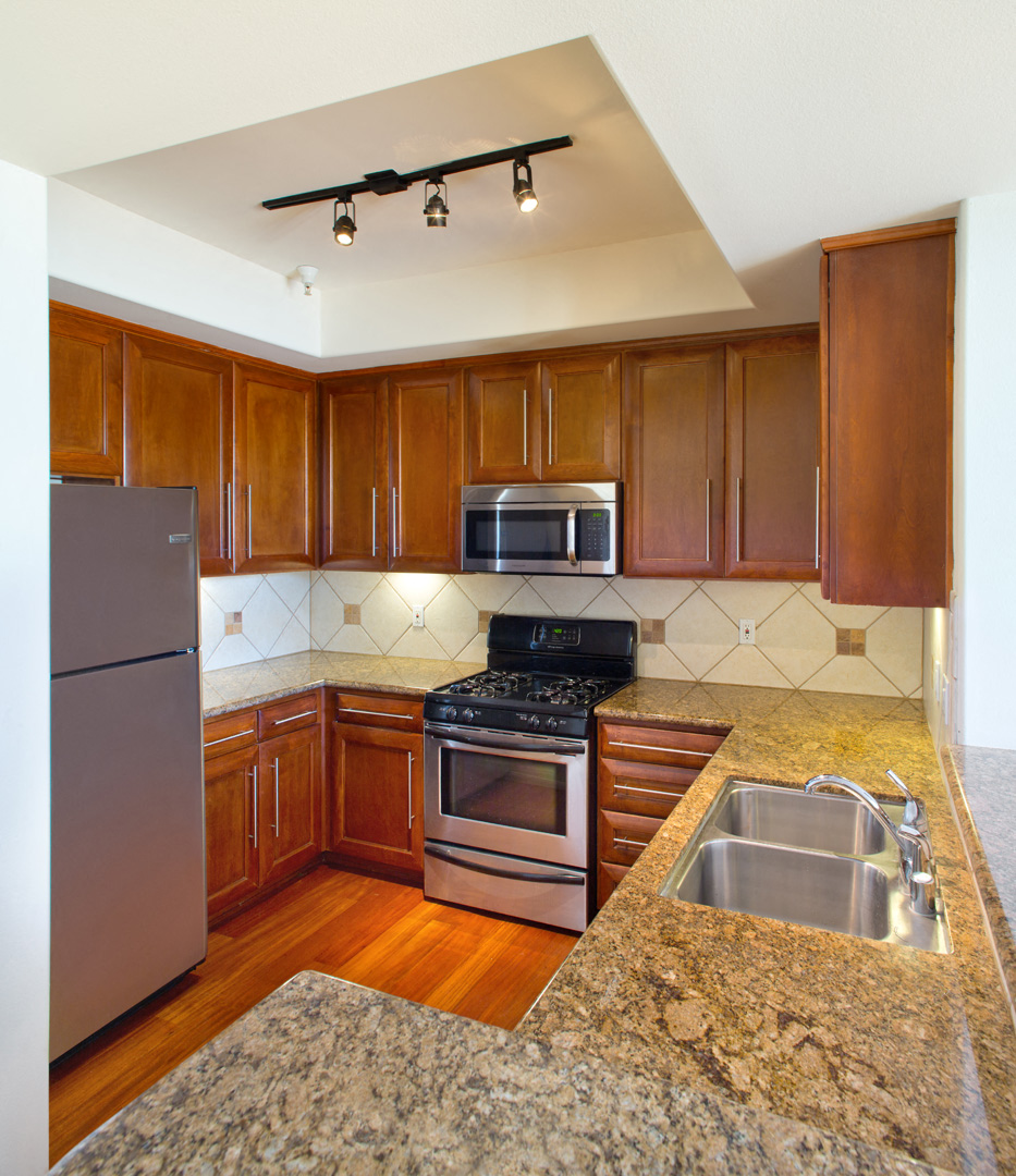 a kitchen with wooden cabinets and granite counter tops and stainless steel appliances