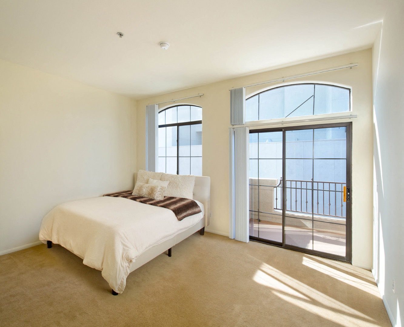 a bedroom with a bed and a large window