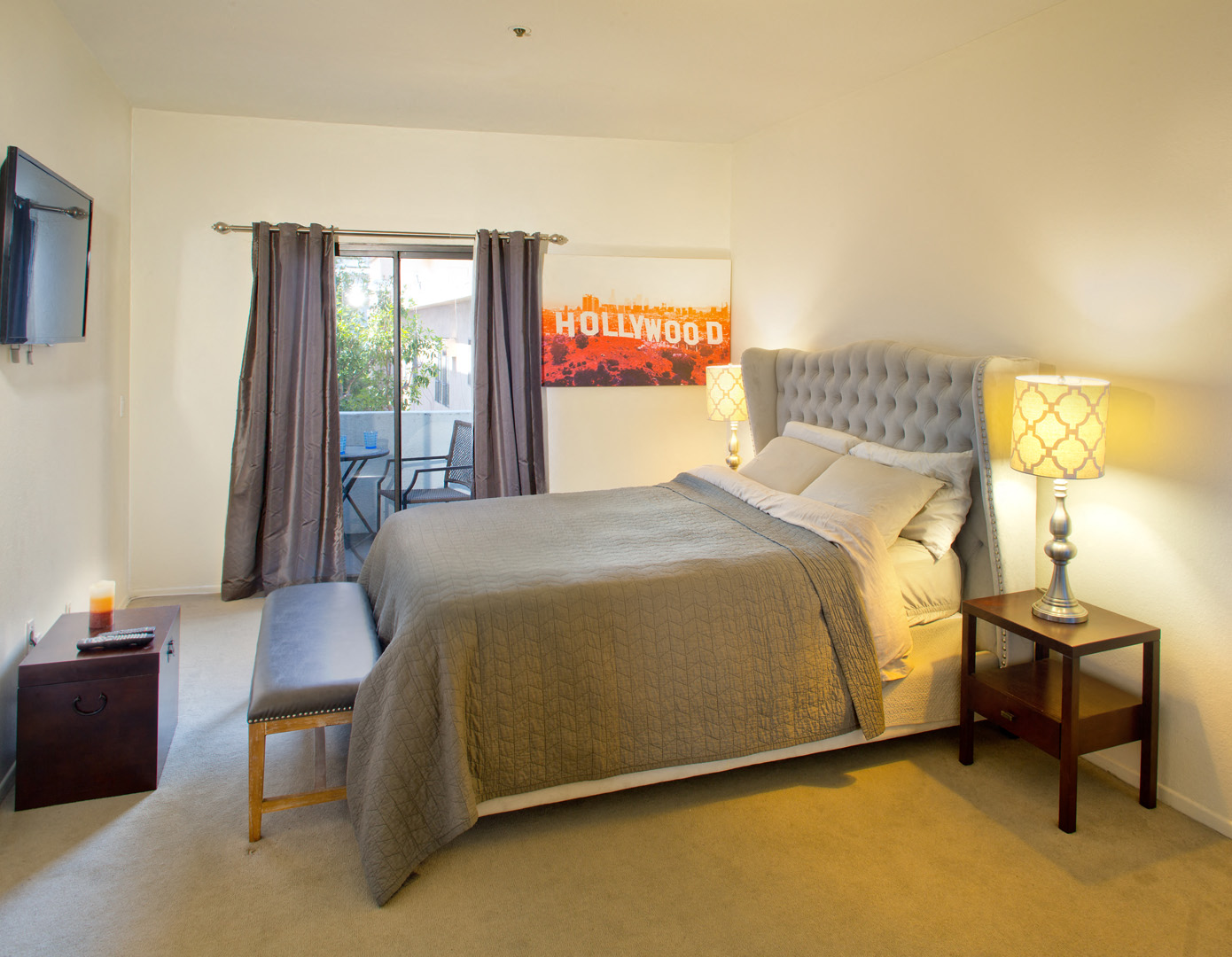 a bedroom with a bed and a chair and a tv