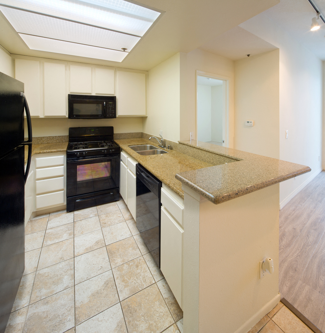 a kitchen with a granite counter top and black appliances