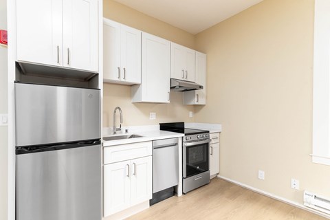 A kitchen with white cabinets and stainless steel appliances.