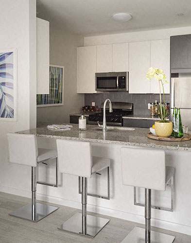 a kitchen with a marble counter top and white cabinets