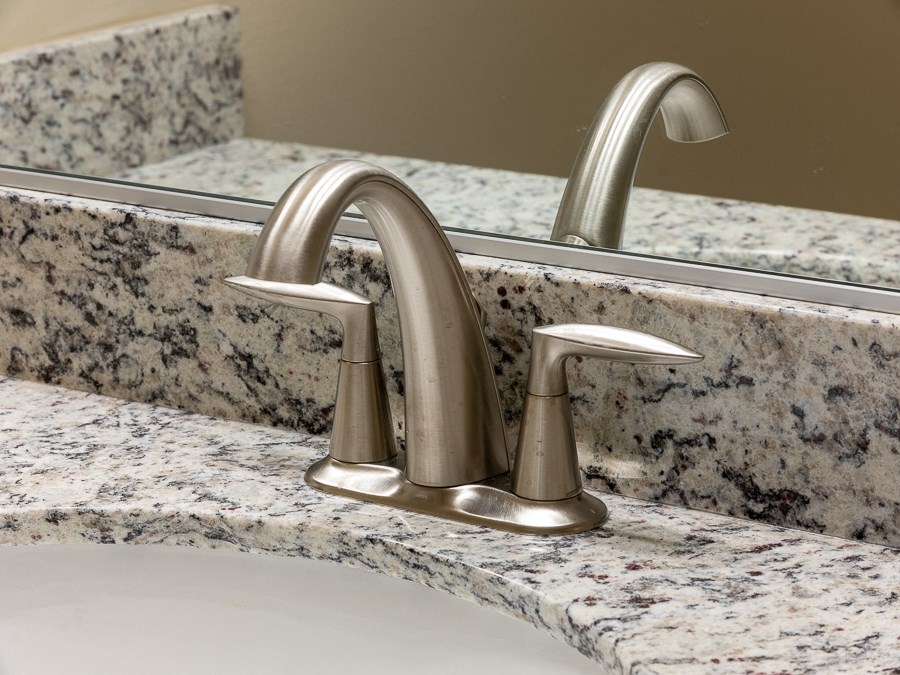 a bathroom sink with a chrome faucet and a mirror