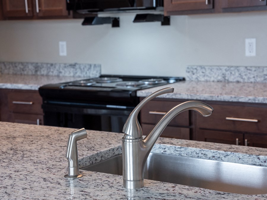 a kitchen with a faucet and granite counter tops