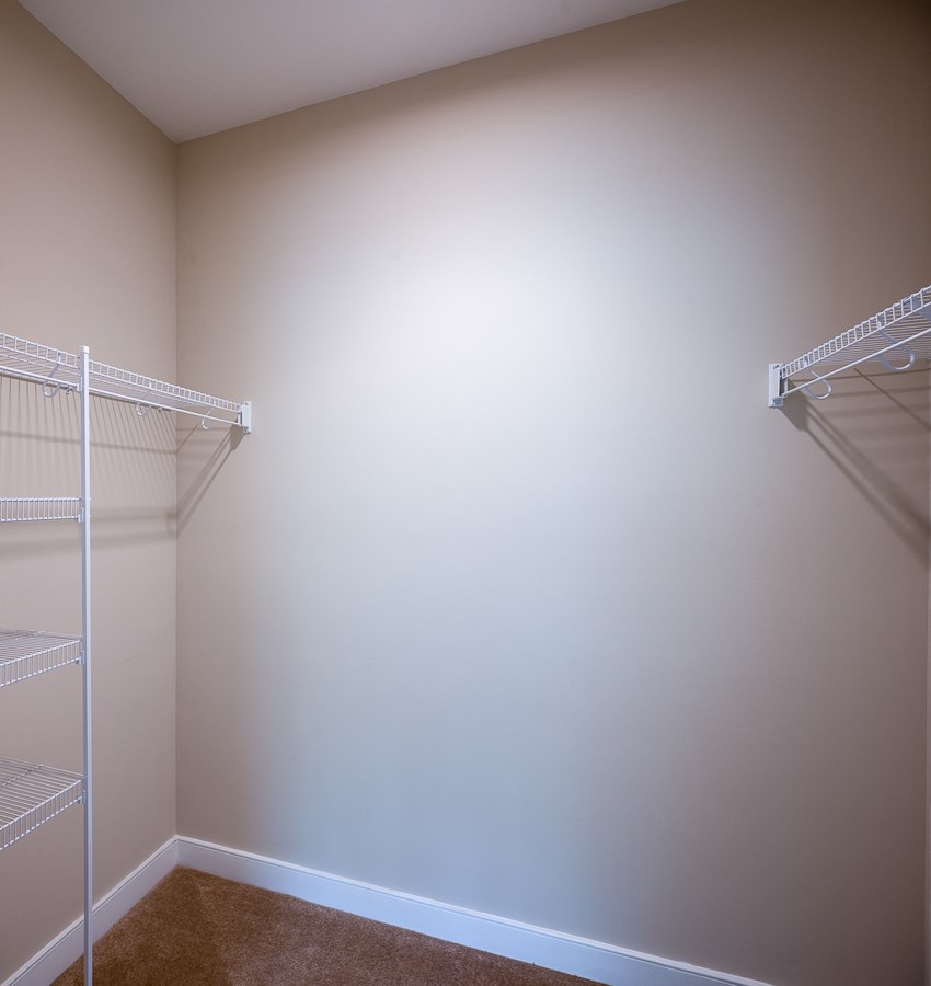 a walk in closet with two mirrored closets in it