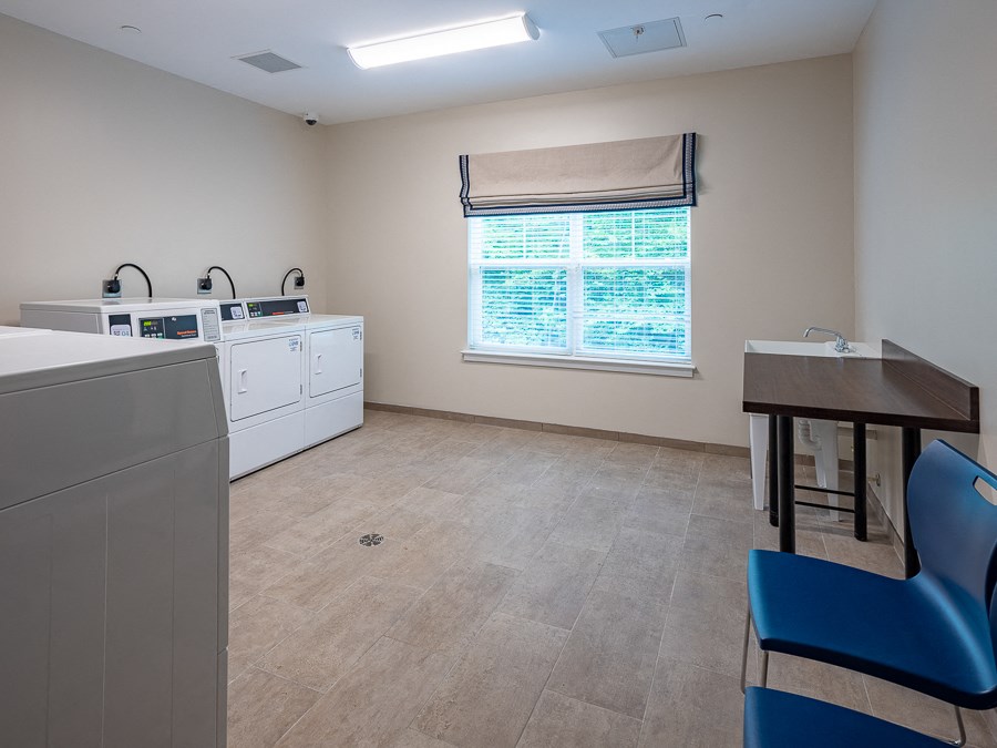 an empty kitchen with a table and chairs and a washer and dryer