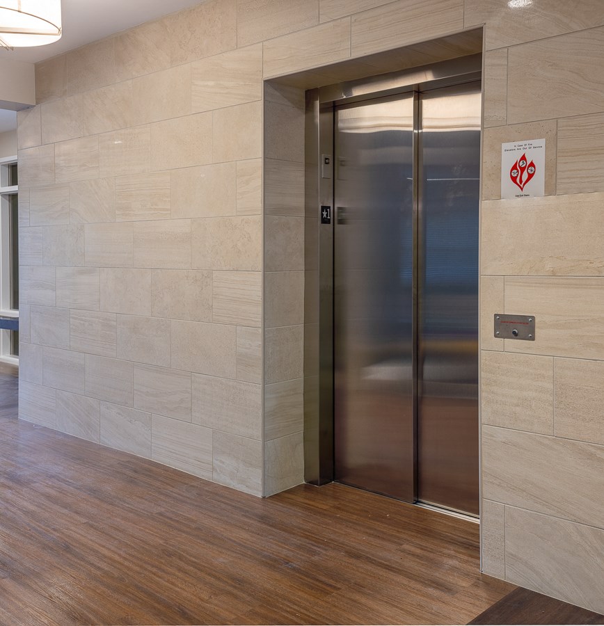 an elevator in the lobby of a building with a wood floor