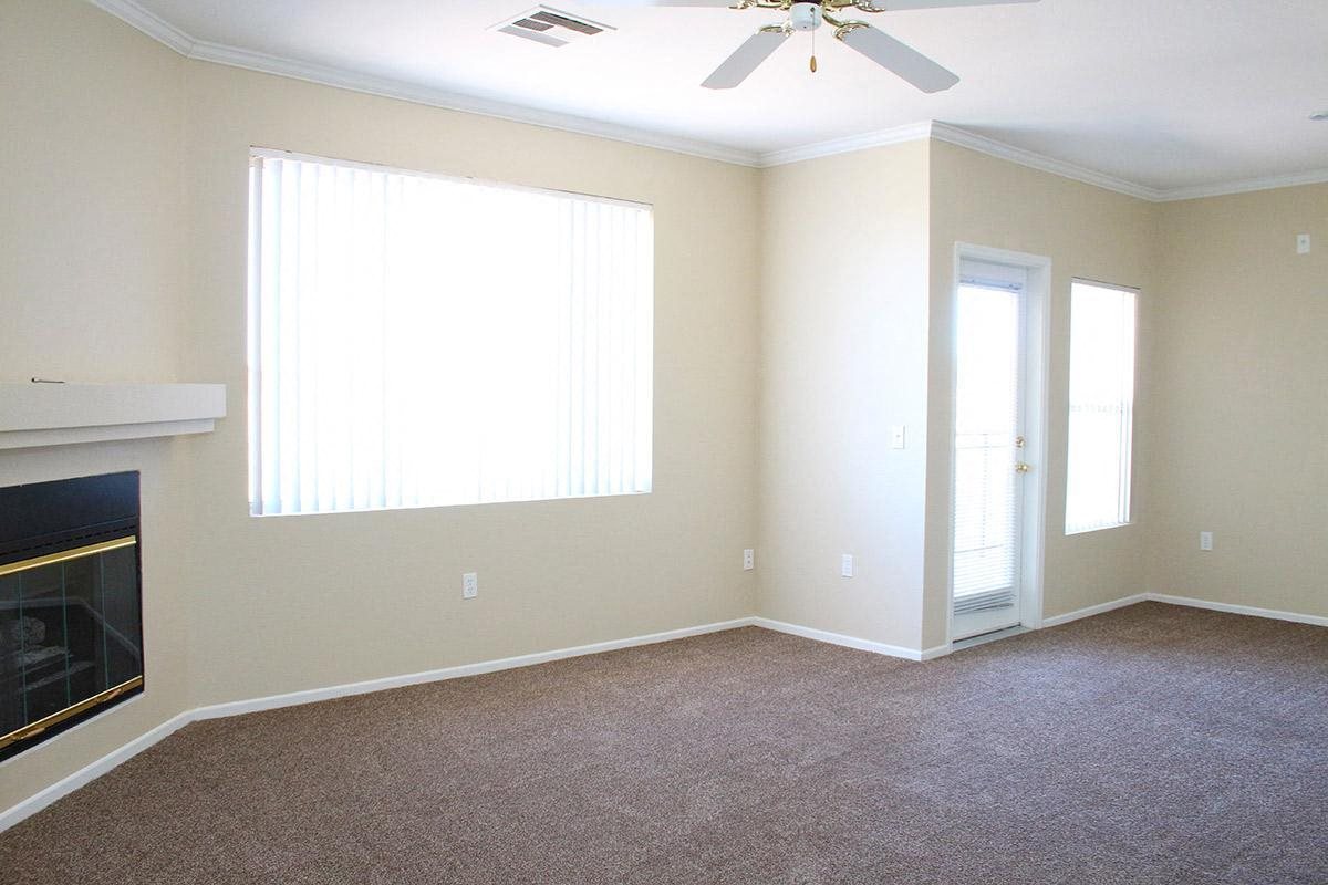 an empty living room with a fireplace and a window
